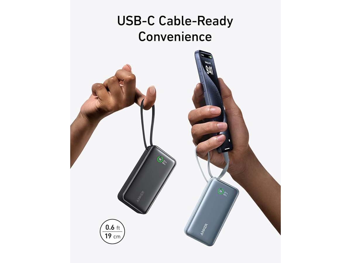 Two hands holding Anker power banks with USB-C cables attached, one connected to a smartphone.